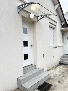 a white house with a white door and stairs at Grand Studio WiFi rapide RER B in Sevran