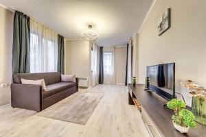 a living room with a couch and a flat screen tv at Warm Mountain Hideout by Flat Manаger in Pamporovo +4 photos