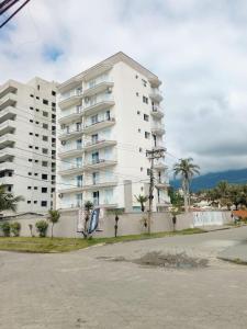 ein großes weißes Apartmenthaus an der Straßenseite in der Unterkunft The Massagua in Caraguatatuba + 14 Fotos