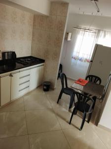 eine Küche mit Tisch und Stühlen und einem Herd in der Unterkunft The Massagua in Caraguatatuba