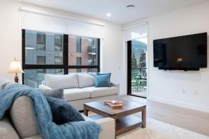 a living room with a couch and a tv at Bluebird by Revelstoke Vacations in Revelstoke