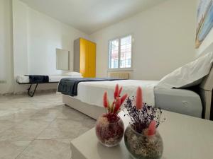 ein Schlafzimmer mit einem Bett und einem Tisch mit Pflanzen in der Unterkunft Amami - Gallipoli in Gallipoli