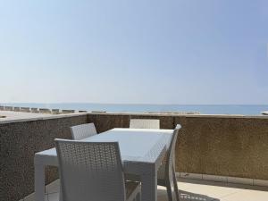 ein Tisch und Stühle auf einem Balkon mit Blick auf den Ozean in der Unterkunft Amami - Gallipoli in Gallipoli