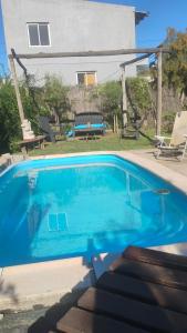 ein blauer Pool vor einem Haus in der Unterkunft CASA SAMARANA Alta Gracia in Alta Gracia
