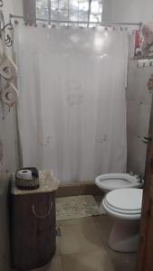 ein Badezimmer mit Toilette und Duschvorhang in der Unterkunft CASA SAMARANA Alta Gracia in Alta Gracia