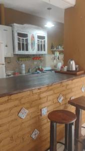 eine Küche mit einer Holzarbeitsplatte mit zwei Hockern in der Unterkunft CASA SAMARANA Alta Gracia in Alta Gracia