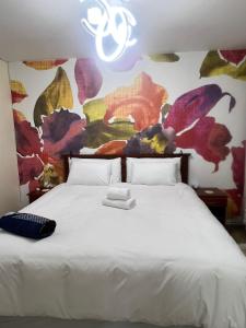 a bedroom with a white bed with a painting on the wall at The Oceanic 42 in Durban