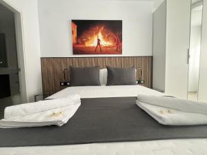 Principado de Aracena II في اراسنا: سريرين في غرفة نوم مع لوحة على الحائط