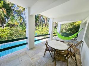 a patio with a table and chairs and a pool at Quinta do Conde in Lauro de Freitas
