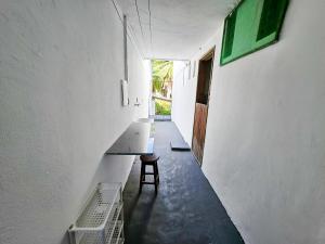 a hallway with a table and a stool in a building at Quinta do Conde in Lauro de Freitas +13 photos
