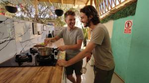 two men are standing at a stove in a kitchen at Puerto Bamboo in Máncora