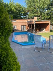 una piscina con due sedie e una casa di Casa quinta a Estación Norte