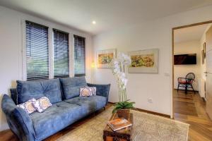 a living room with a blue couch and a mirror at Face à la mer - Grande terrasse in Macinaggio