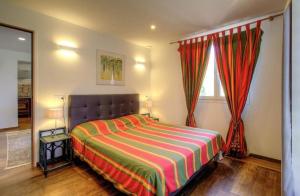 a bedroom with a large bed with a striped blanket at Face à la mer - Grande terrasse in Macinaggio