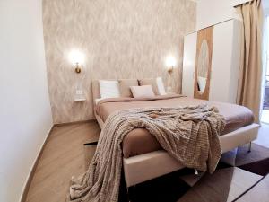 ein Schlafzimmer mit einem Bett, auf dem eine Decke liegt in der Unterkunft Mastedè in Tivoli
