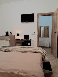 een slaapkamer met een bed en een bureau met een televisie bij Mastedè in Tivoli