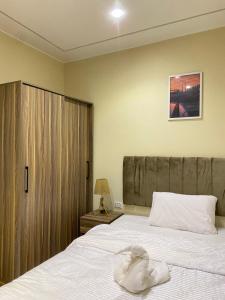 1 dormitorio con 1 cama grande y puerta de madera en Good Nights Pyramids Hotel, en El Cairo