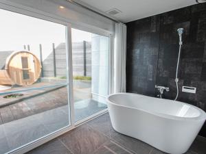 Una bañera en un baño con una ventana grande. en Kubikai, en Itoshima