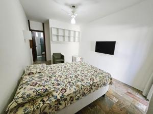a bedroom with a bed and a television in it at Quinta do Conde in Lauro de Freitas