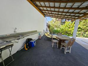 a patio with a table and chairs and a sink at Quinta do Conde in Lauro de Freitas