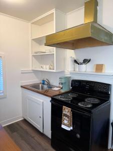 a kitchen with a black stove and a sink at Cozy Modern Studio - Heart of Lafayette in Lafayette +2 photos