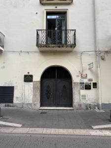 Le Muse Loft في كازيرتا: مبنى فيه باب اسود وبلكونه