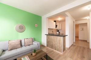 a living room with a couch and a kitchen at Le Vert Calme in Le Havre