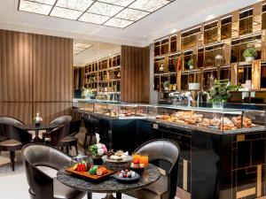 a restaurant with tables and chairs and a buffet at Admiral Hotel Manila - MGallery Collection in Manila