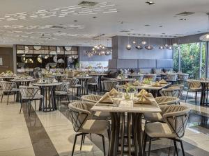 uma sala de jantar com mesas e cadeiras em um restaurante em Novotel Suites Manila at Acqua em Manilla