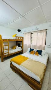 a bedroom with two beds and two bunk beds at Baku Laureles Hostel in Medellín