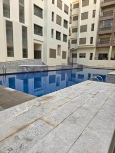 a swimming pool in front of a building at super studio in Aïn Harrouda