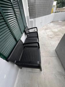 a black bench sitting on the side of a building at Serenity Apartment in Funchal +1 photo