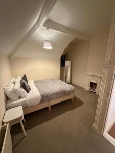 Spacious Home - Solihull Town Centre- Near NEC-BHX في سوليهال: غرفة نوم بسرير كبير في العلية