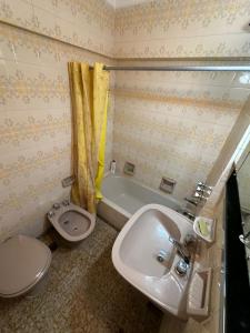 a bathroom with a sink and a toilet and a tub at La Perla Mar y Sol in Mar del Plata +18 photos
