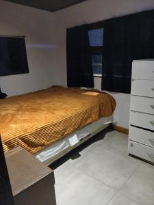 Cabaña lumar في San Eduardo del Mar: غرفة نوم بسرير وخزانة ونافذة