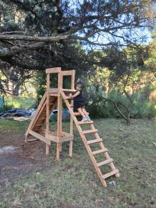 Cabaña lumar في San Eduardo del Mar: طفل صغير يتسلق سلمًا على هيكل لعب خشبي
