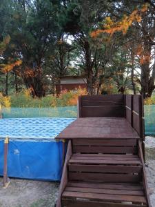 Cabaña lumar في San Eduardo del Mar: مقعد خشبي موضوع فوق طاولة زرقاء