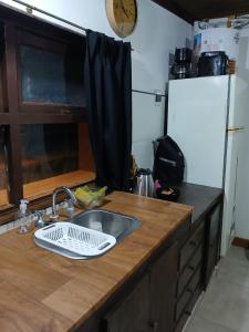 Cabaña lumar في San Eduardo del Mar: طاولة مطبخ مع حوض وساعة