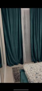 un lit dans une camionnette avec des rideaux verts dans l'établissement Apartament Târg Craciun, à Craiova