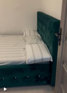 un lit avec une tête de lit verte à côté d'une porte dans l'établissement Apartament Târg Craciun, à Craiova