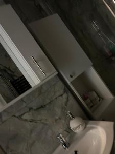 une salle de bains avec un lavabo et un miroir dans l'établissement Apartament Târg Craciun, à Craiova