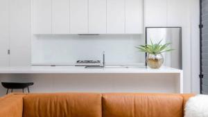 a living room with a couch and a kitchen at The Avenue in Sawtell +8 photos