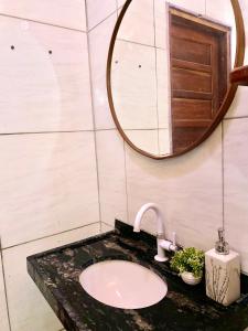 un bagno con lavandino e specchio di Casa da Helô a Icapuí