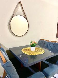 un tavolo con specchio e un vaso con dei fiori sopra di Casa da Helô a Icapuí