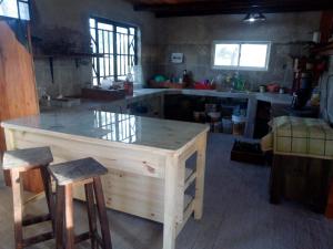 a kitchen with a large wooden island with two bar stools at Cabaña Mbaretecua in Paso de la Patria