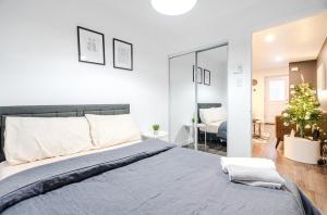 a bedroom with a large bed and a living room at Griffintown Central 2BR in Montreal
