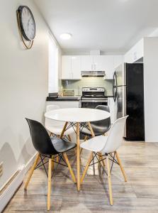 a kitchen with a table and chairs and a clock on the wall at Griffintown Central 2BR in Montreal