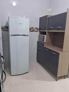 プライア・グランデにあるCasa condomínio residencial Praia Grandeの白い冷蔵庫と電子レンジのあるキッチン