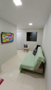 プライア・グランデにあるCasa condomínio residencial Praia Grandeのベッドと壁掛けテレビのある寝室 +12枚の写真