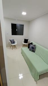 プライア・グランデにあるCasa condomínio residencial Praia Grandeの白い部屋(ベッド1台、椅子2脚付)